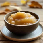 Compote de rhubarbe et pommes dans un bocal en verre sur une planche en bois