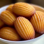 Gros plan sur une madeleine coupée en deux révélant sa texture moelleuse et aérée