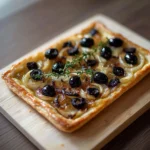 Part de pissaladière niçoise avec oignons confits et filets d’anchois